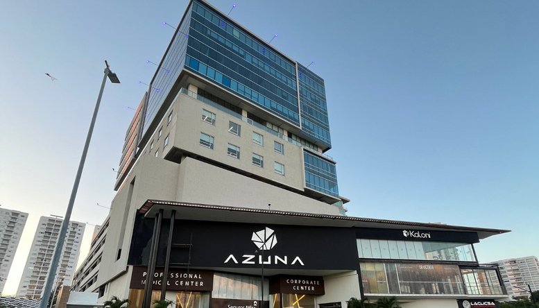 Exterior view of the modern Azuna building with its distinctive glass facade and retail base.