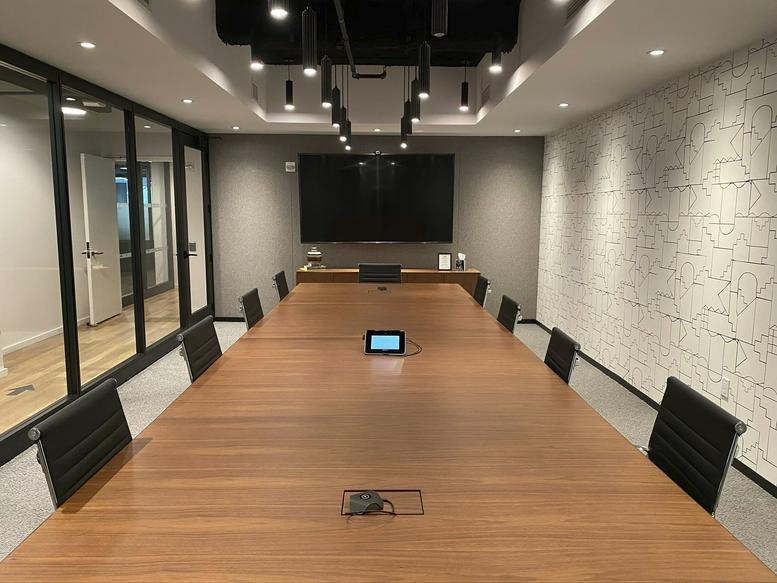 Large formal boardroom with a long wooden table and integrated screen at 300 Park Avenue, 2nd Floor, Grand Central.
