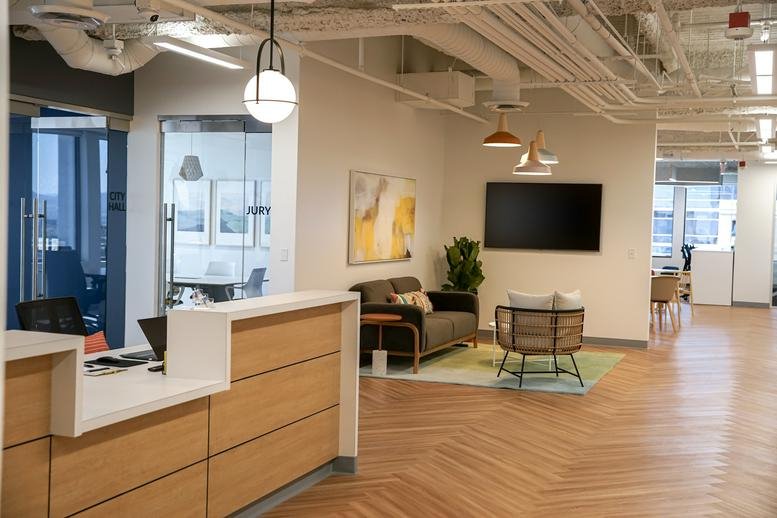 Modern reception area with a wood-paneled desk and a comfortable seating lounge.