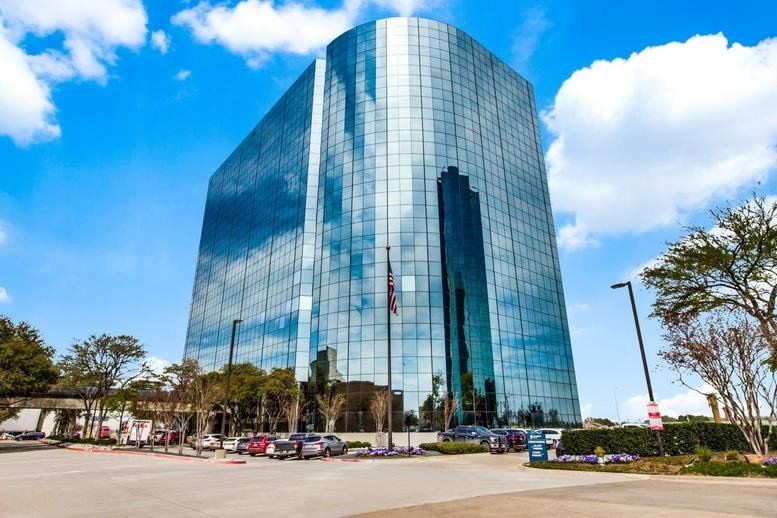 Exterior view of the blue glass-facade building at 3010 LBJ Freeway.