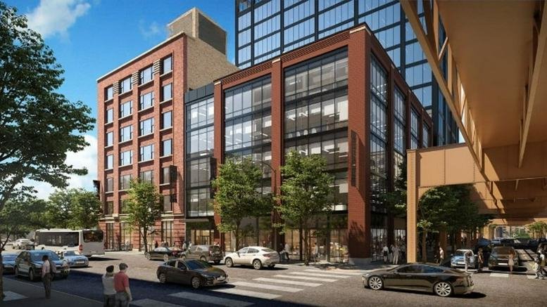 Exterior brick and glass facade of the 306 West Erie Street building at a busy city intersection.