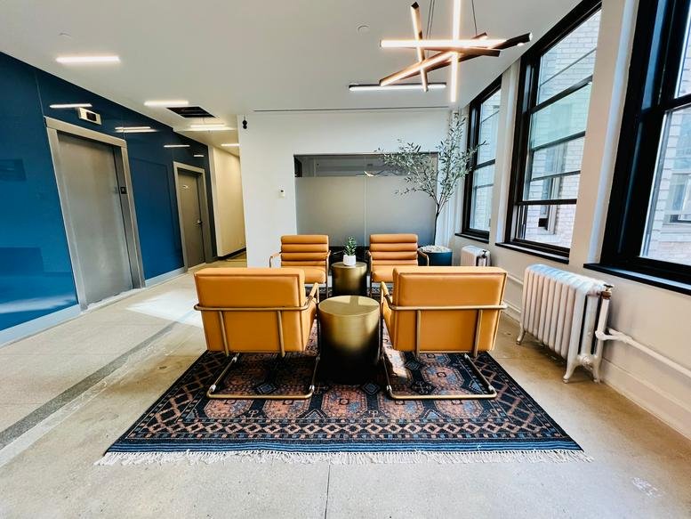 Modern reception lounge with tan leather chairs and a geometric rug at 307 West 38th Street, 16th floor, New York City.
