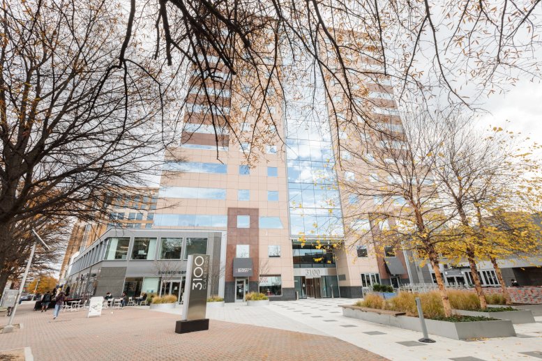 Street-level view of the multi-story glass and stone facade at 3100 Clarendon Boulevard.