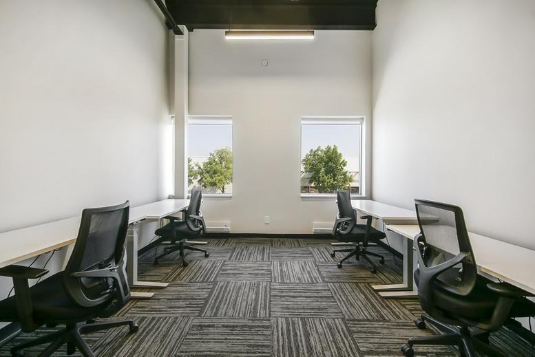 Symmetric office suite with four desks and dual windows.