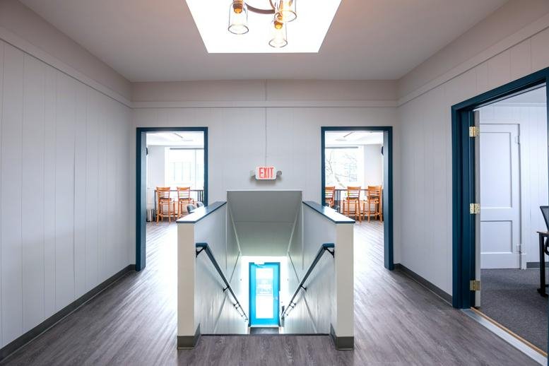 Spacious hallway with wood-style flooring and stairs at 324 West Main Street, Brighton (Michigan).