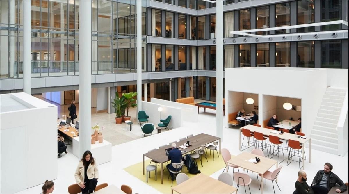 Bright, high-ceiling atrium at 33 West Franklin Street, 2nd & 3rd Floor with modern white furniture.