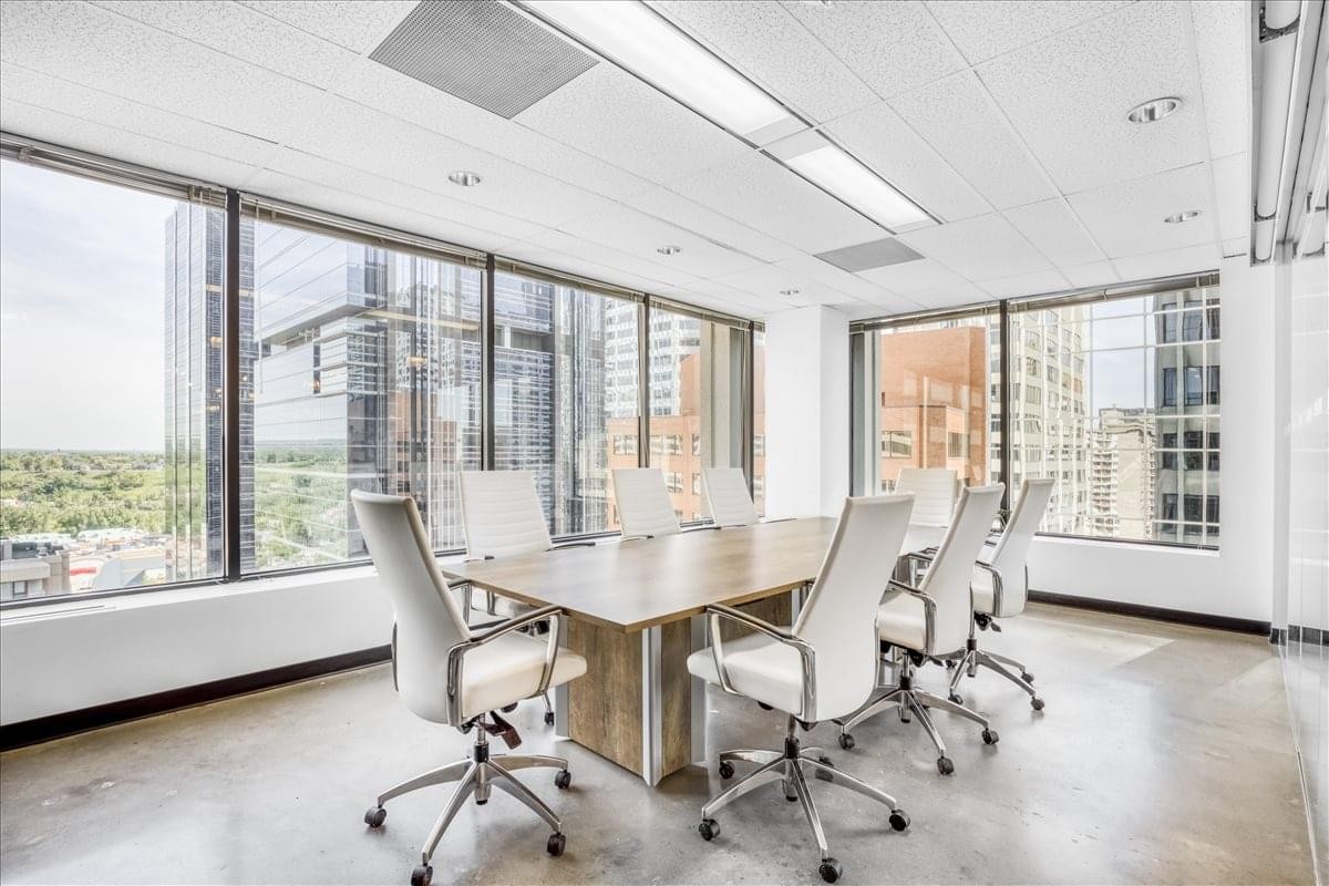 Professional boardroom at 330 5th Avenue South West with city views and white leather chairs.