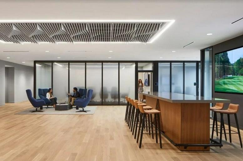 Spacious communal lounge with a large kitchen island, bar seating, and a decorative acoustic ceiling.