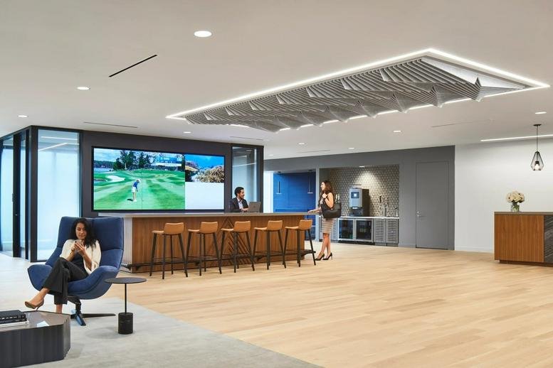 Spacious social hub at 3344 Peachtree Road Northeast featuring a wooden bar, seating, and golf simulator.