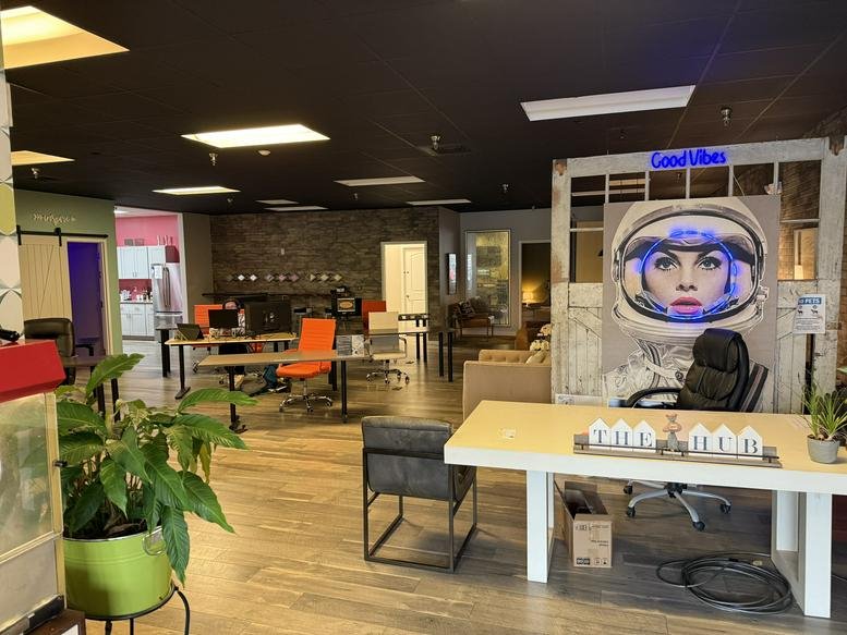 Open-plan workspace with various seating options and astronaut mural.