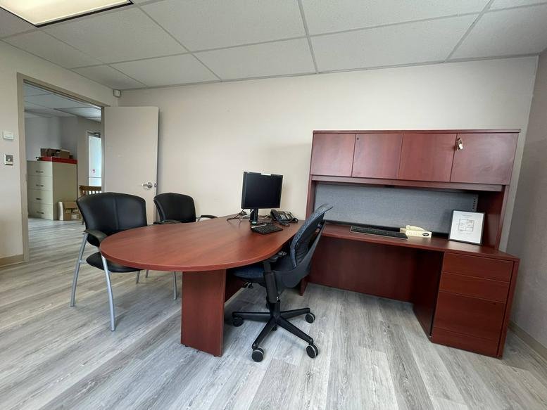 Private office suite with a curved executive desk, secondary workspace, and tall storage cabinets.