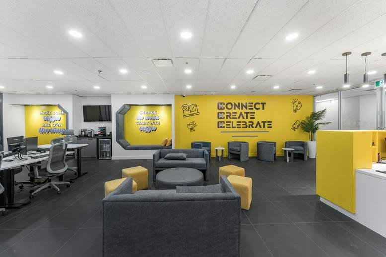Spacious communal lounge at 350, Burnhamthorpe Road West, Unit 200, with yellow feature walls and grey seating.