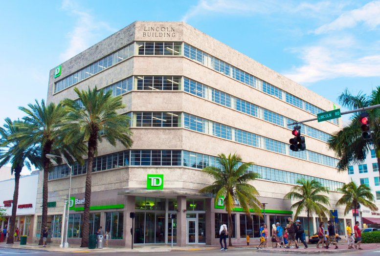 Exterior view of the art deco style Lincoln Building at 350 Lincoln Road with palm trees and street life.