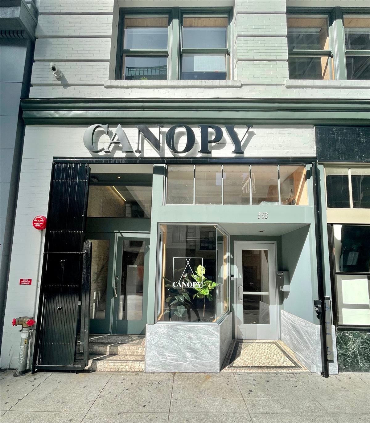 Street-level entrance of 353 Kearny Street featuring glass doors and a modern storefront.