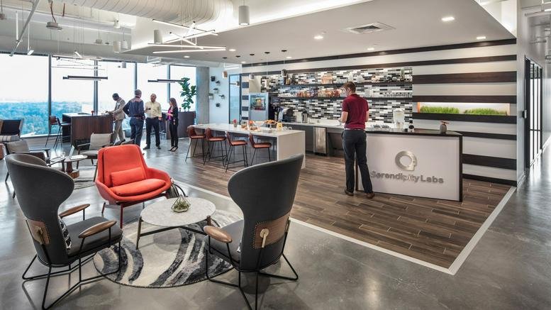 Modern lounge and reception area with stylish wingback chairs, striped walls, and a wood-paneled floor.