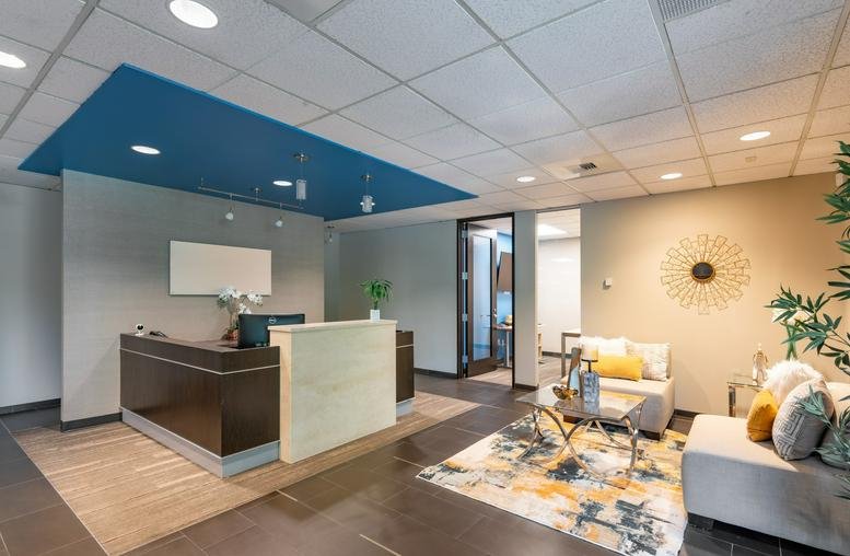 Bright lobby area at 3600 136th Pl SE, 270 with a dark wood reception desk and blue ceiling accent.