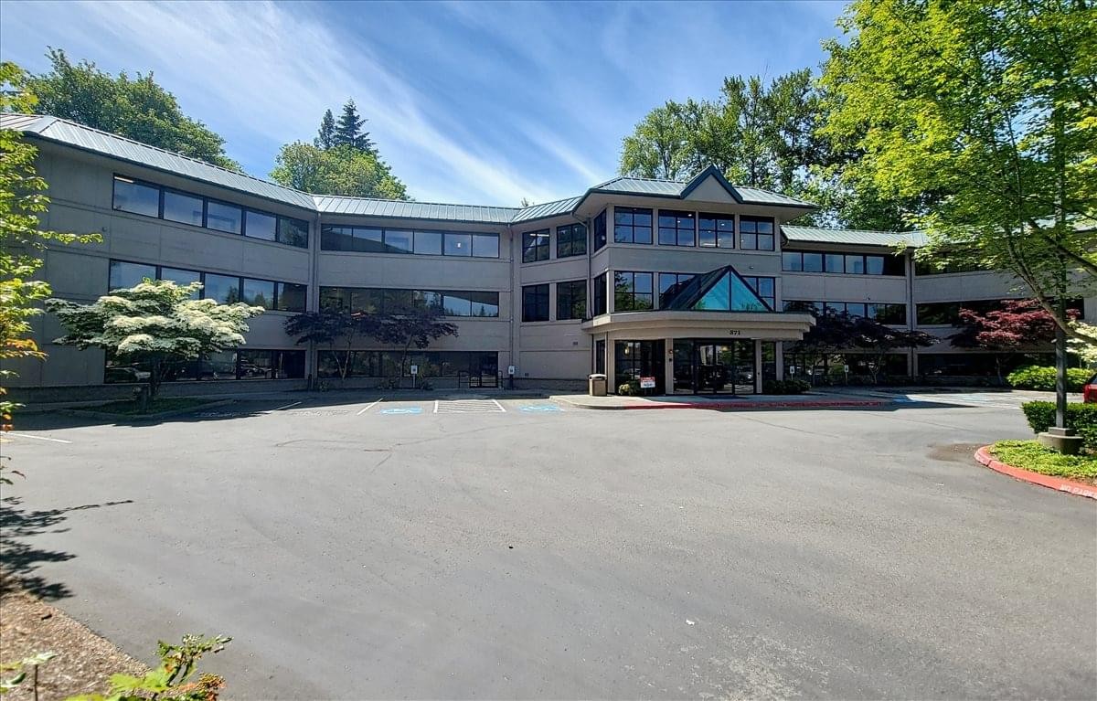 Exterior view of the office building at 371 Northeast Gilman Boulevard with a modern facade and surrounding trees.