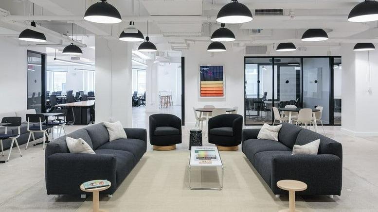 Spacious lounge area with dark sofas, black armchairs, and numerous dome pendant lights.