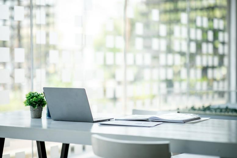 Bright, modern workspace at 3835 Gulfway Drive, Pioneer Park, featuring a laptop and plant on a white desk.