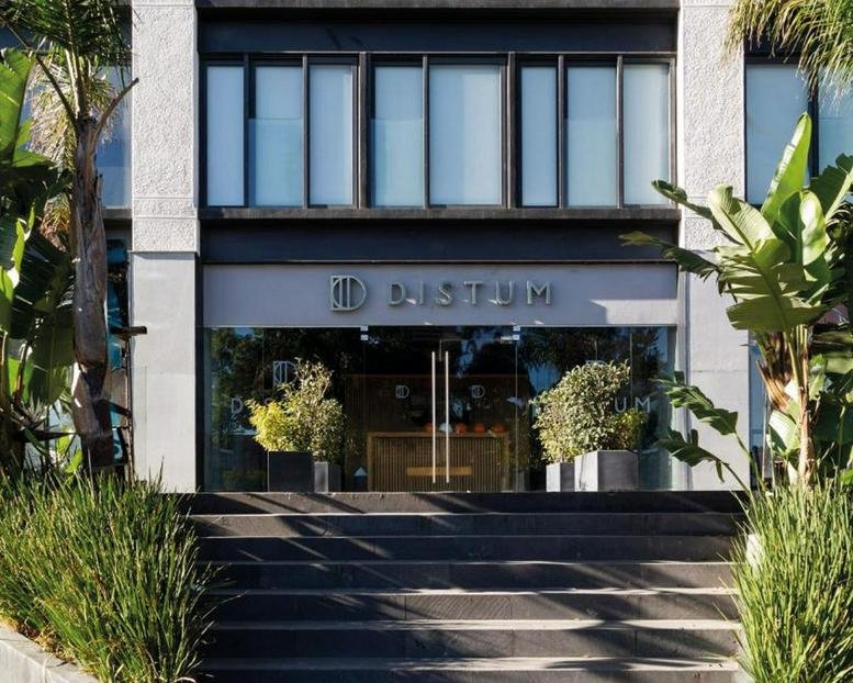 Exterior entrance of the 385, Avenida Marina Nacional building with glass doors and potted plants.