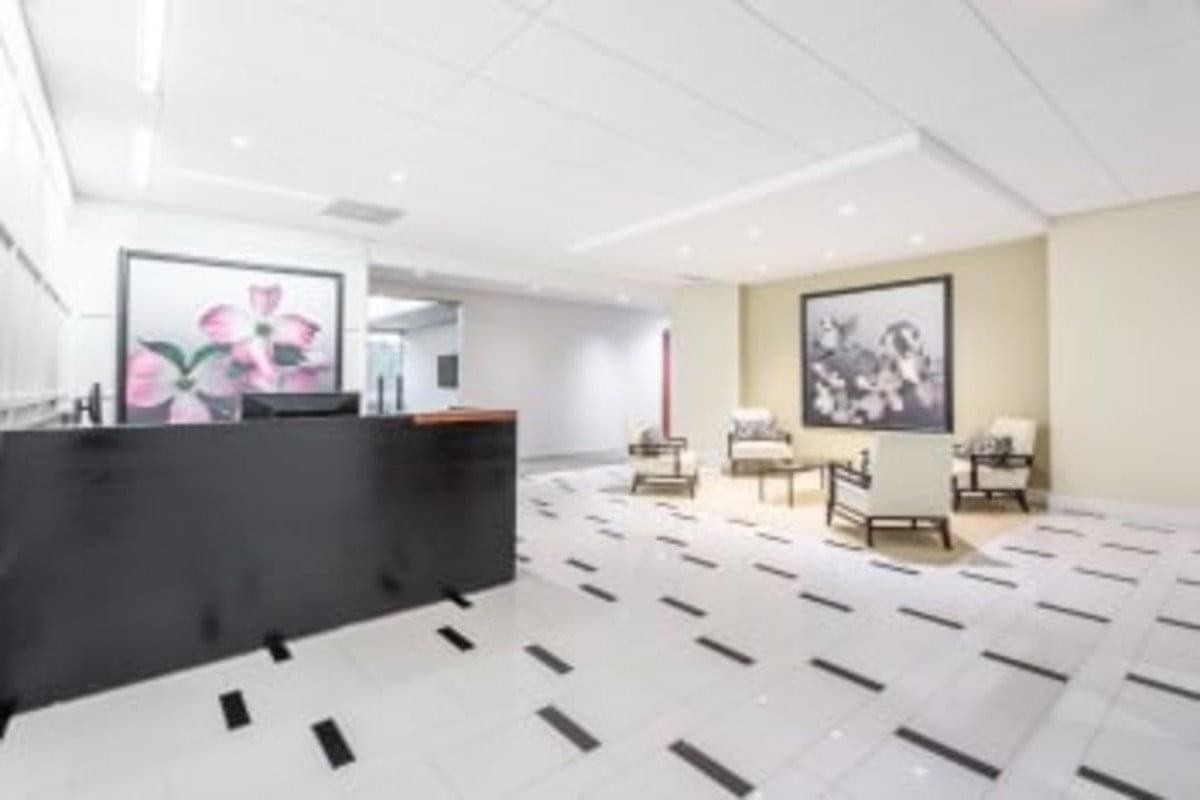 Spacious reception area at 3900 Westerre Parkway, Suite 300 with black desk and floral artwork.