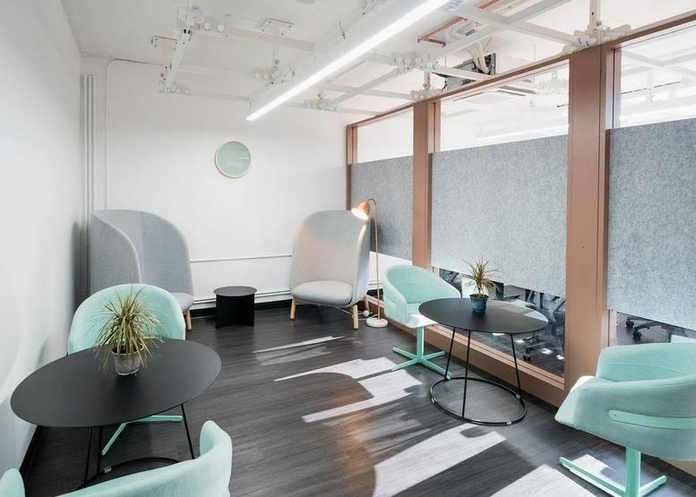 Modern lounge area at 4 West 4th Avenue, Downtown, San Mateo, California with turquoise chairs and soundproof pods.