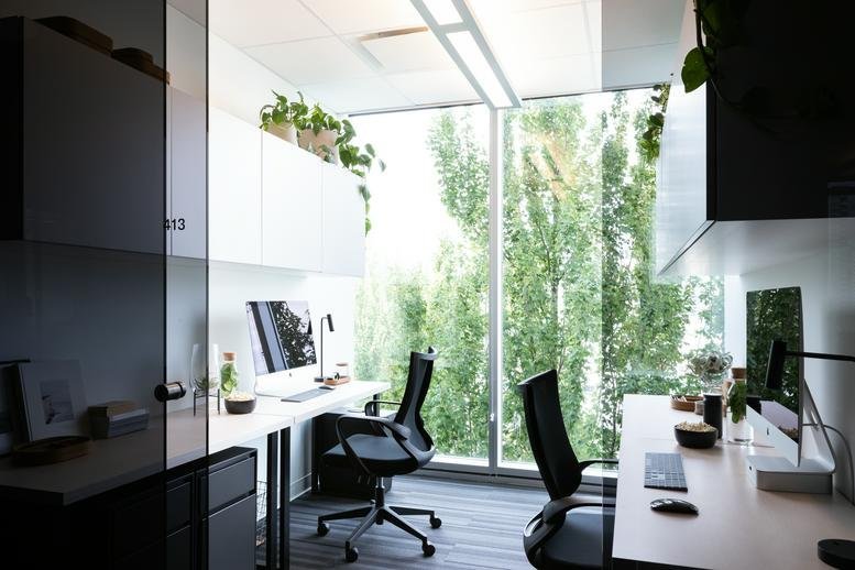 Bright open-plan workspace at 400, 22 East 5th Avenue with white desks and lush green trees outside.