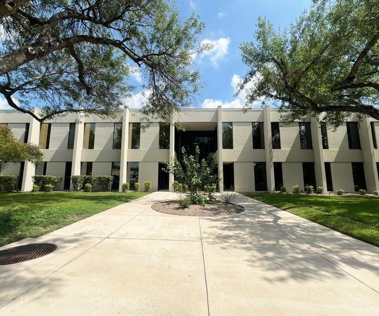 Exterior view of the light-colored office building at 4100 East Piedras Drive.