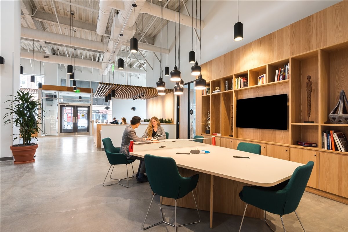 Bright, modern lobby at 42-49 South Meridian Street, 2nd Floor with wood shelving and a large meeting table.