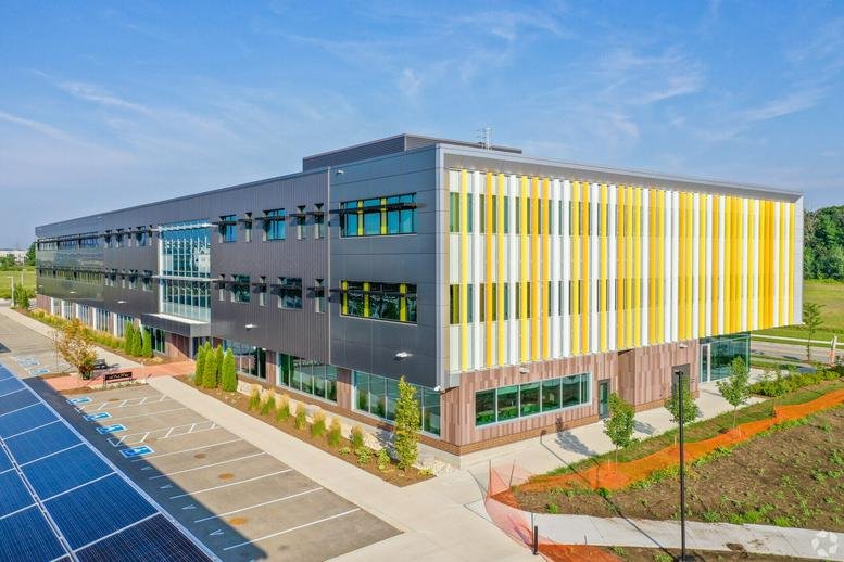 Modern exterior showing the building's facade with distinctive yellow and grey vertical panels.
