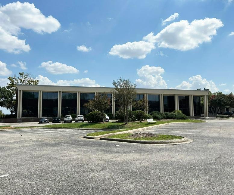 Exterior view of the long, glass-fronted office building at 4241 E Piedras Dr, San Antonio, Texas.