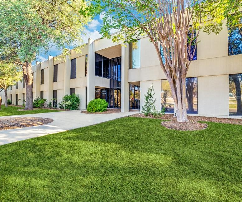 Exterior view of the light-colored office building at 4243 East Piedras Drive.