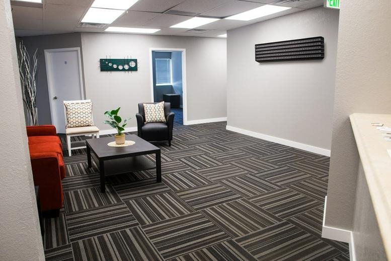 Reception and lobby area at 439 South Union Street, Suite 206, with striped carpet and an orange sofa.