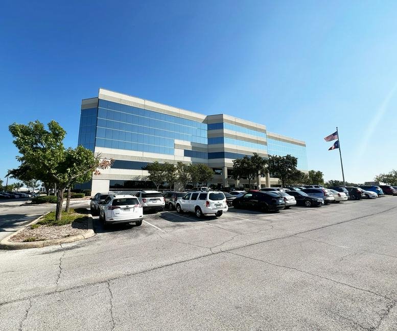 Sunny exterior of the multi-story glass office building at 4400 NorthWest Loop 410.