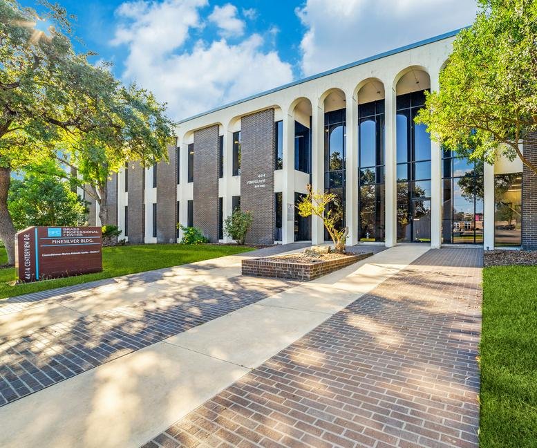 Arched facade and brick exterior of 4414 Centerview Drive with a paved walkway.