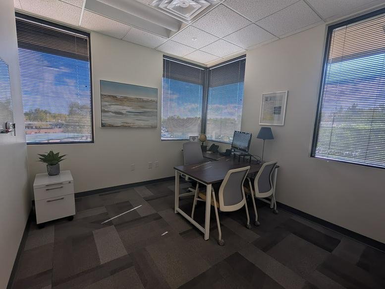 Bright private office with corner windows and a small workstation at 443, East Chandler Boulevard Suite 200.