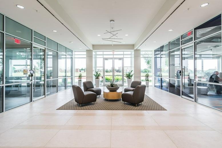 Spacious contemporary lobby at 450 Century Pkwy, Ste 250 with glass walls and central lounge seating.