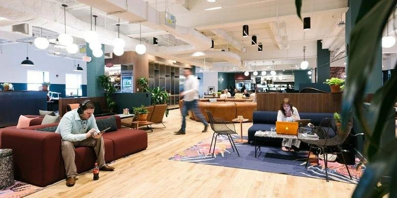 Spacious, modern lounge at 450 Park Avenue South with plush red sofas and natural light.