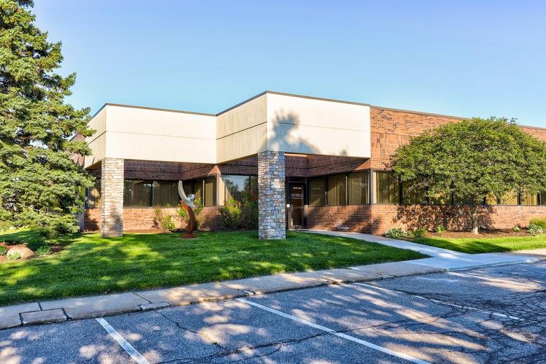 Exterior facade of the brick and stone office building at 4750 Venture Dr, Suite 400.