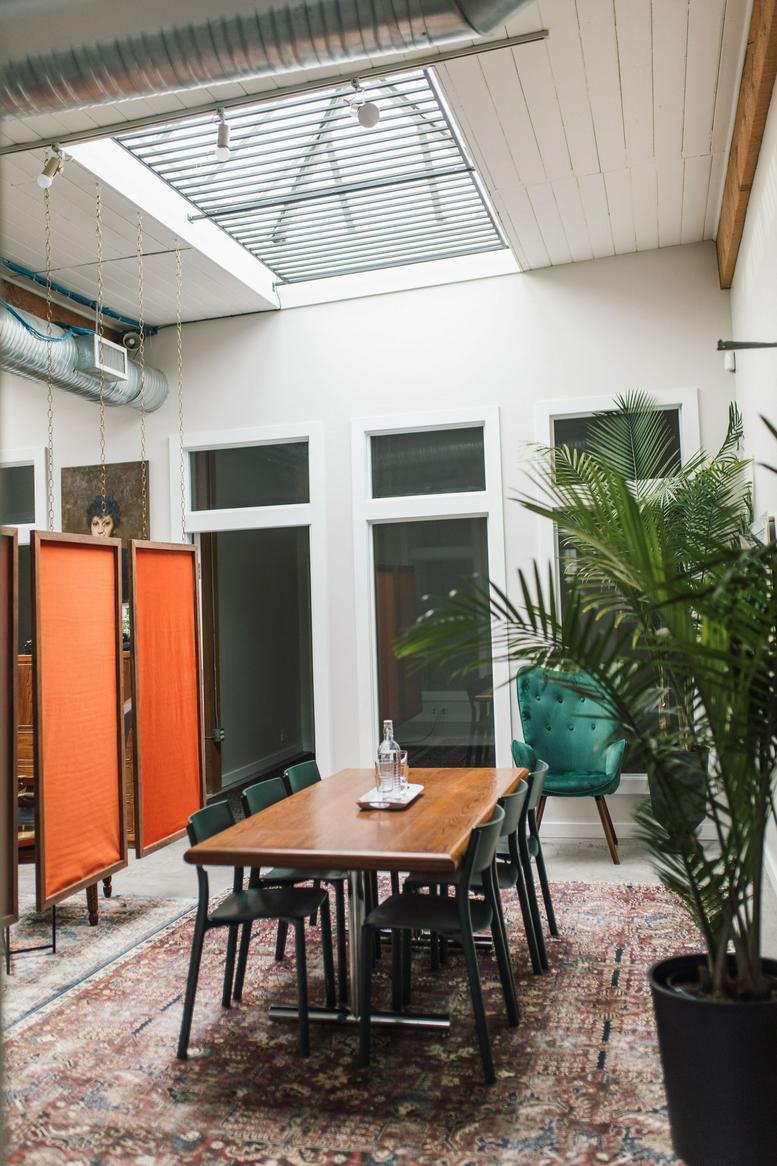Spacious dining and breakout area at 49 Dunlevy Avenue, Suite 220 with natural light from a skylight.