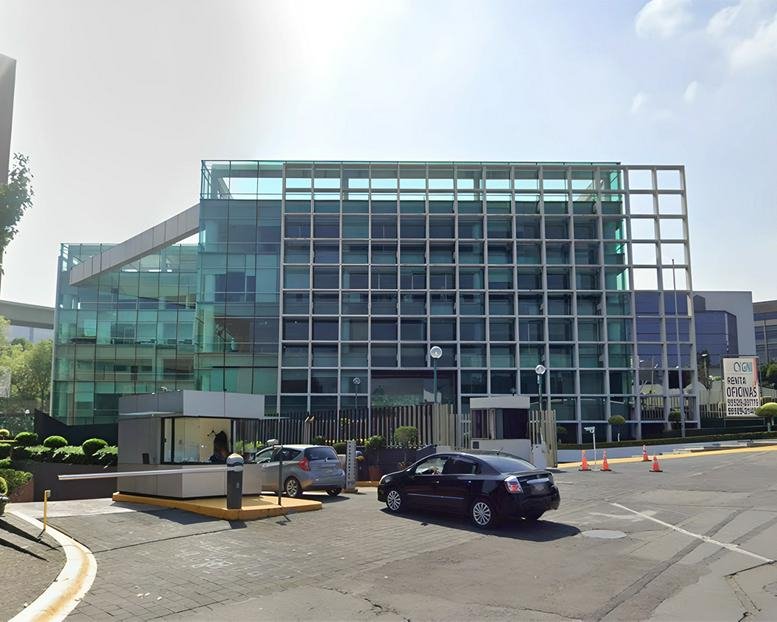 Wide street view of the modern glass and grid building at 50, Alfonso Nápoles Gándara, Mexico City.