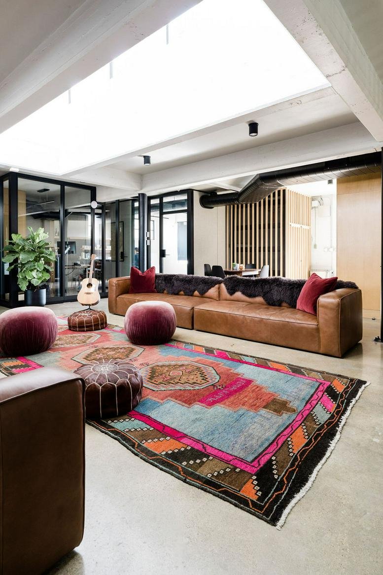 Vibrant lounge area at 500 6th Street featuring a leather sofa and a colourful patterned rug.