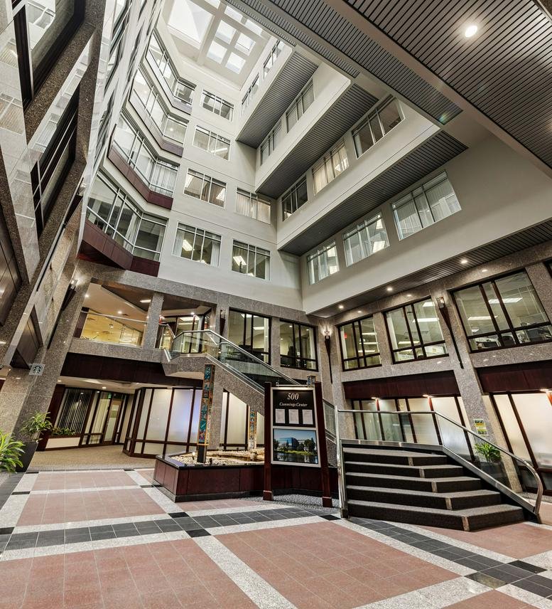 Multi-story indoor atrium with a grand staircase and skylights.