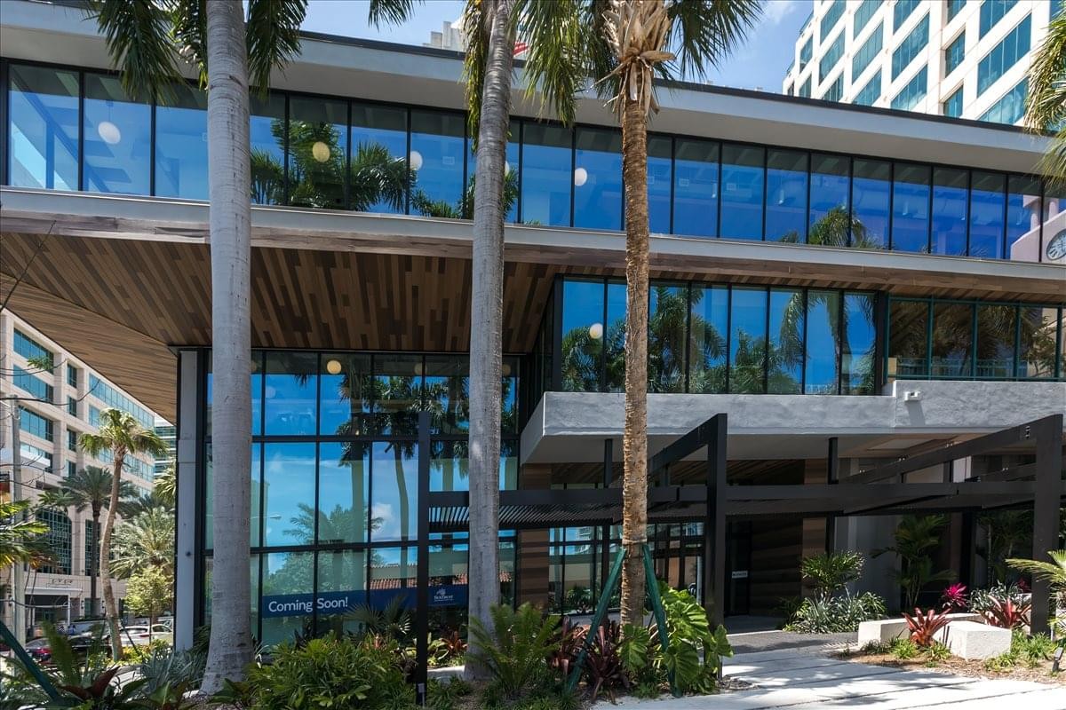 Exterior view of the modern glass and concrete building at 501 East Olas Blvd, Suite 200 and 300.