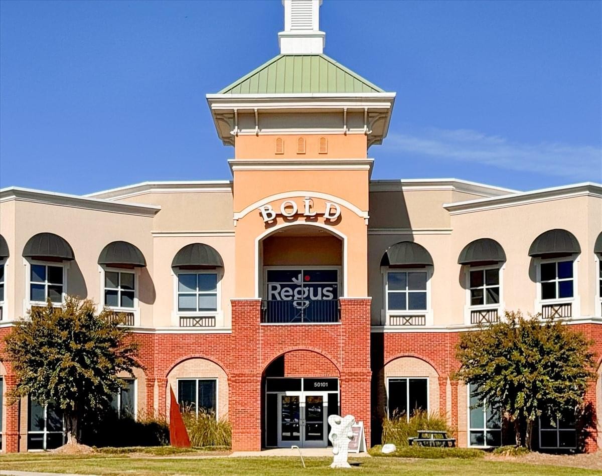 Exterior view of the peach and brick Bold Building with a central clock tower.