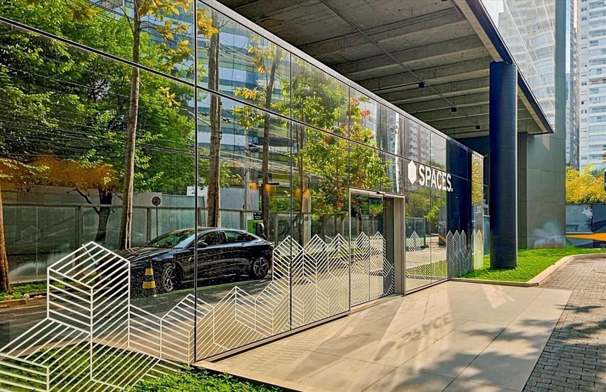 Reflective glass building exterior with greenery.