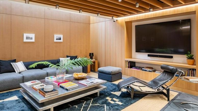 Wood-paneled lounge at 525 Broadway, SoHo, Manhattan, New York City with a large TV and modern seating.