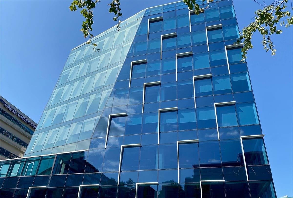 Exterior view of the blue glass-facade 525 West 8th Avenue building.
