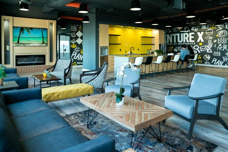 Spacious communal lounge at 5343 Dundas Street West with colorful seating and a view of the kitchenette.