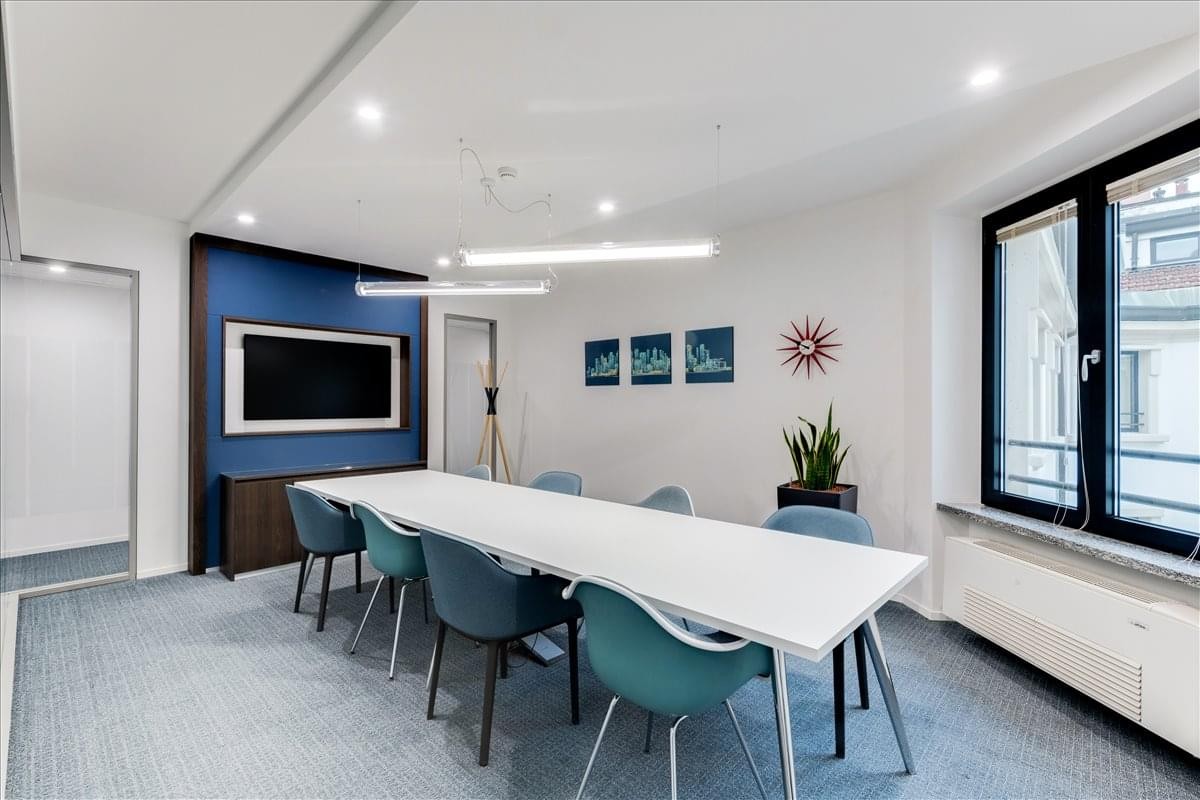 Professional meeting room at 544 Lakeview Parkway, Suite 100 featuring a long white table and blue accent wall.